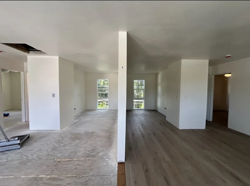 Finished open-plan living area with hardwood flooring in a custom home remodel